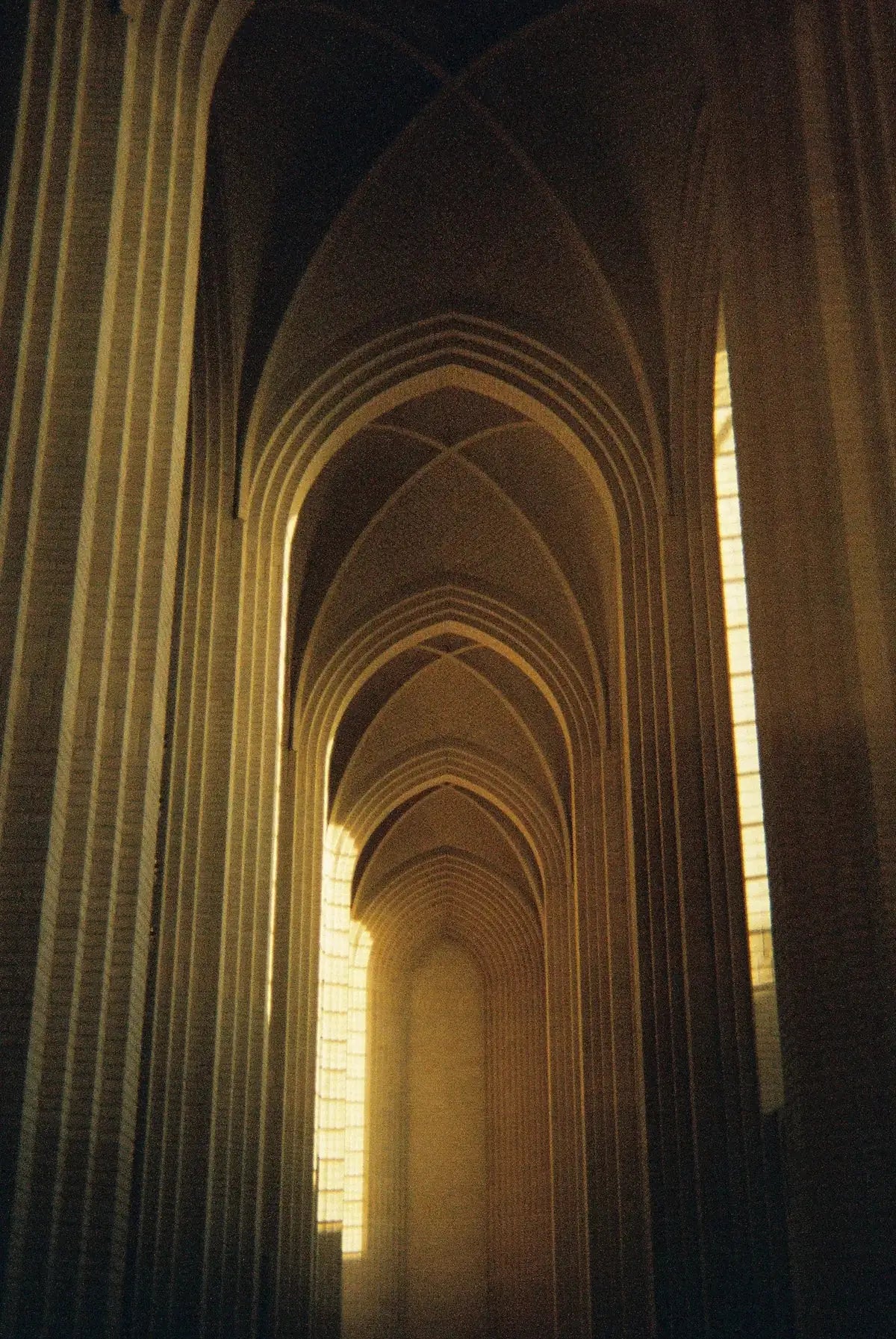Golden light through a long arched corridor