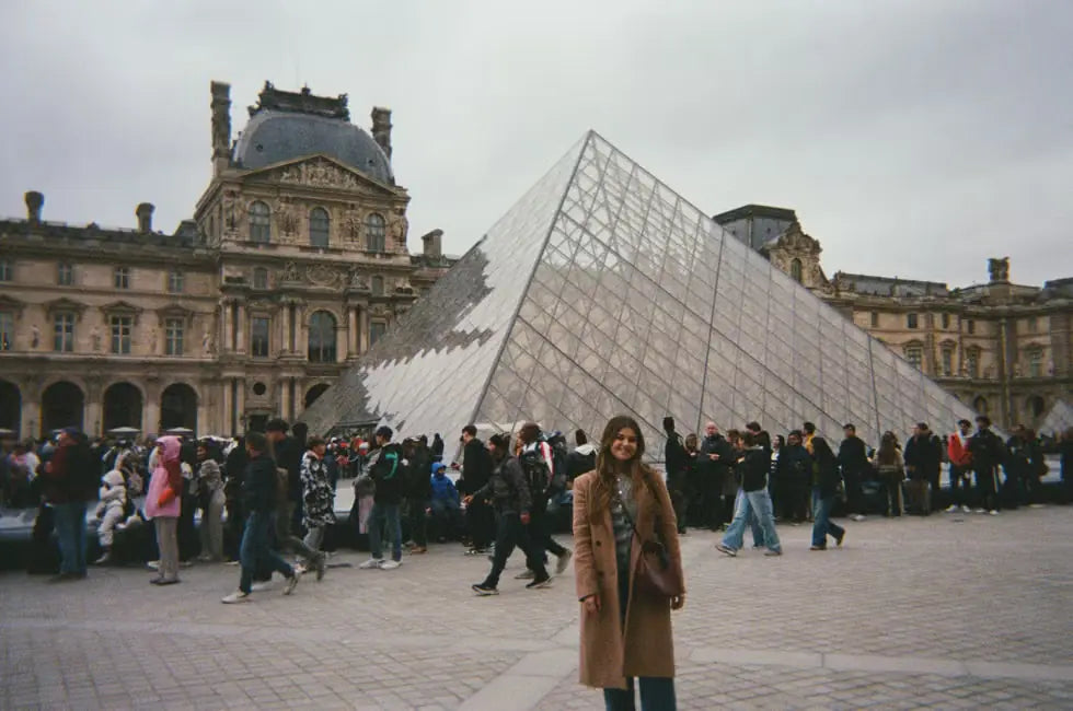 A woman in front of the Louvre pyramid, shot on OH—TWO Digital Film